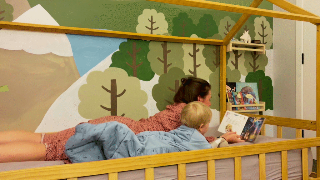 mom reading to toddler on bed