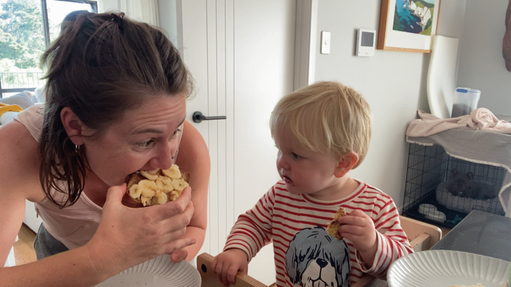 breastfeeding mom eating mid-morning snack in front of toddler