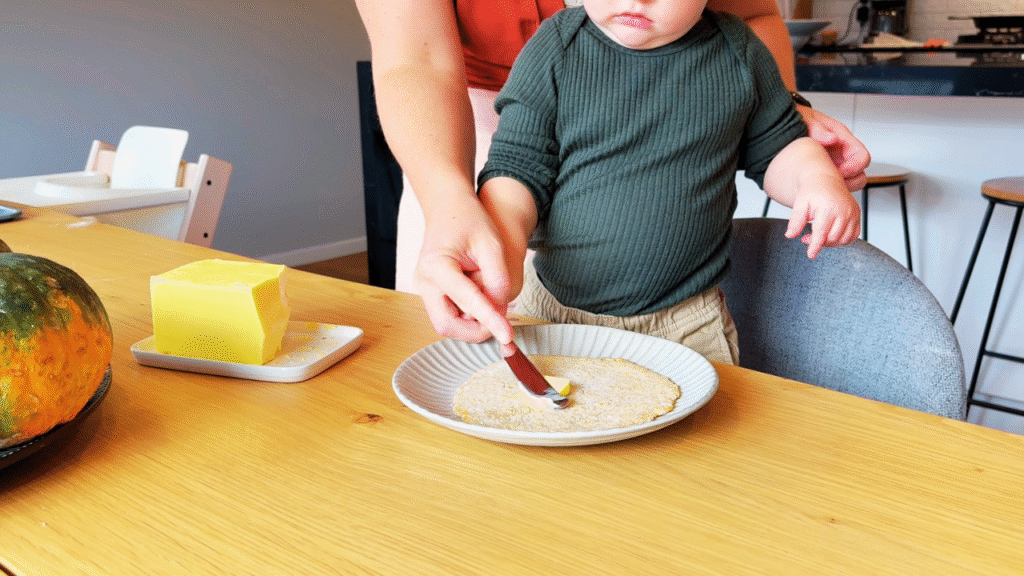 toddler helping to butter flatbread for lunch