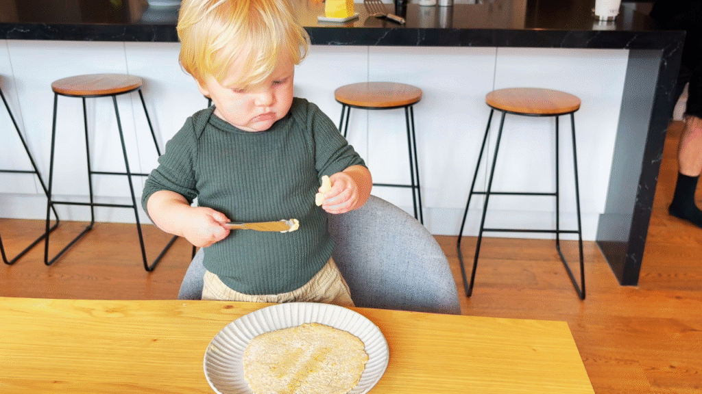 toddler helping to butter flatbread for lunch