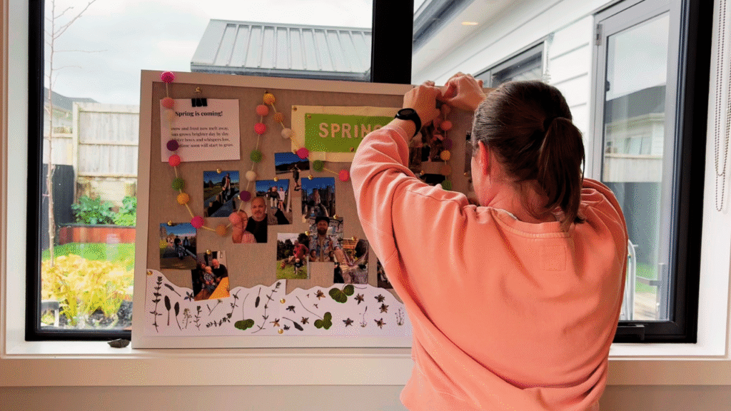 Mom adding decorations to toddler spring rhythm board 
