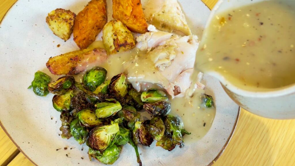 from scratch gravy being poured over meal at the table