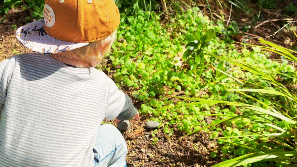 toddler collecting a stone for a waldorf inspired prop for story telling