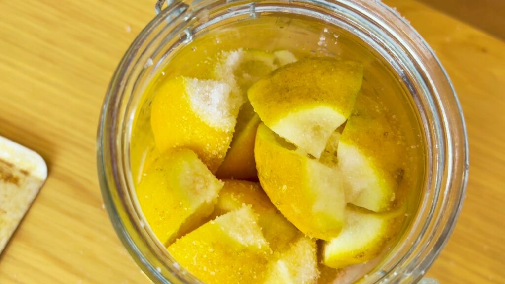 lemons cut and sandwiched in glass jar with salt