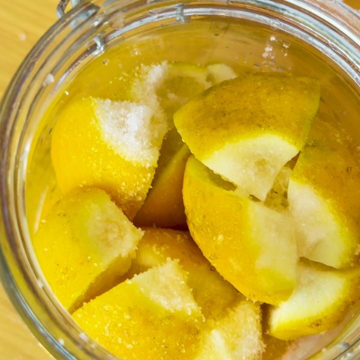 lemons cut and sandwiched in glass jar with salt