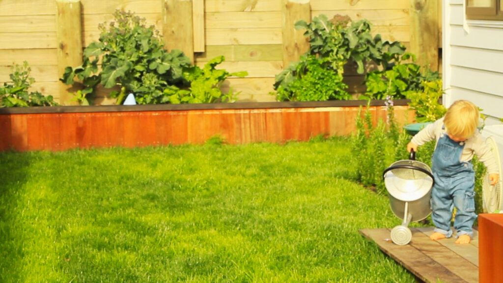 Toddler using garden tools to help in the garden