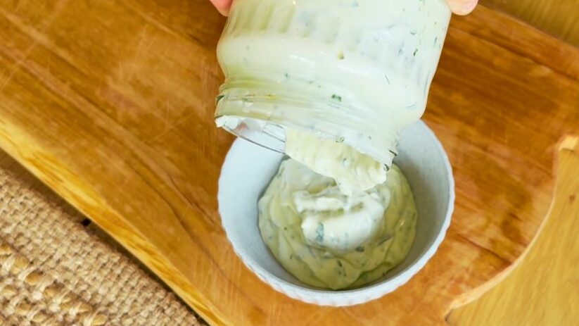 Pouring seed oil free herb mayo from jar into bowl