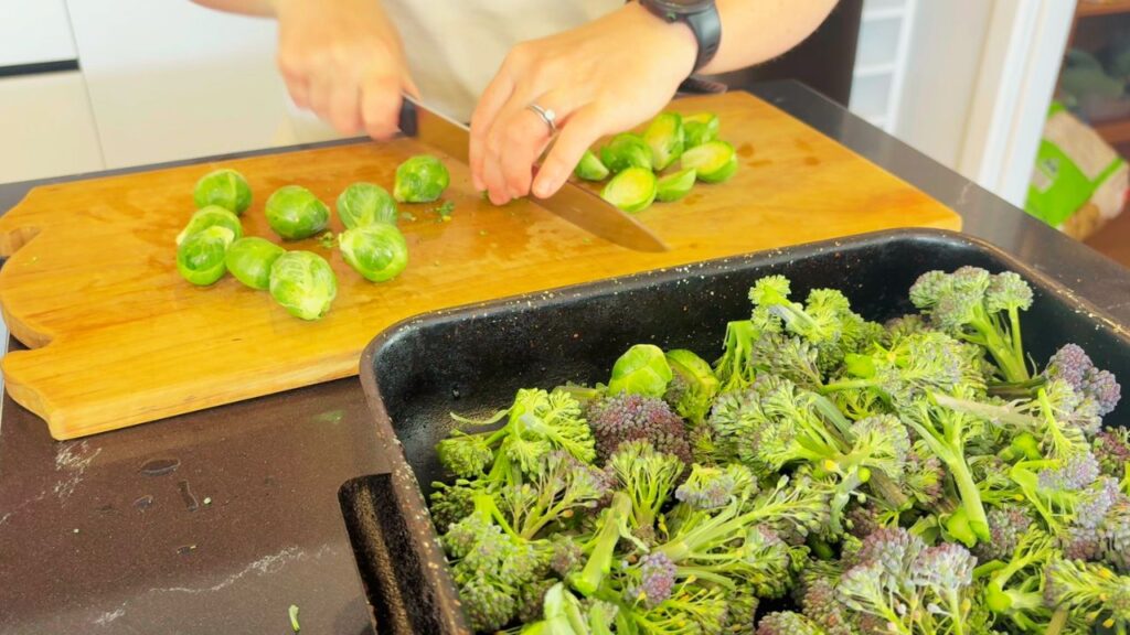 mom chopping brussel sprouts to roast with broccoli