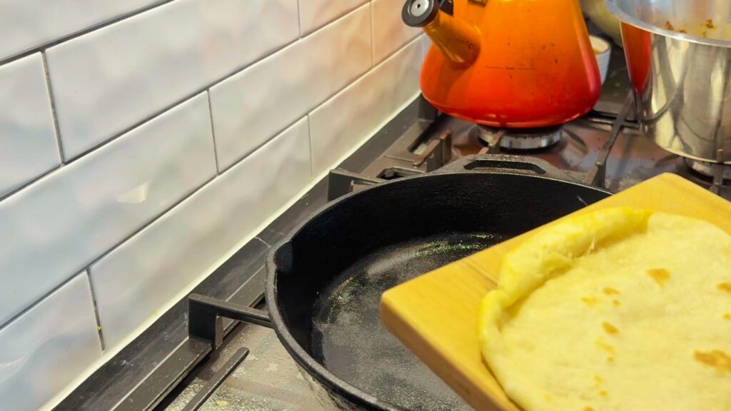 Cooking a golden sourdough discard wrap in a cast-iron skillet for a seed-oil-free bread alternative.