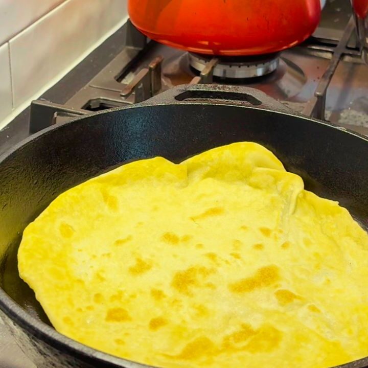 Cooking a golden sourdough discard wrap in a cast-iron skillet for a seed-oil-free bread alternative.