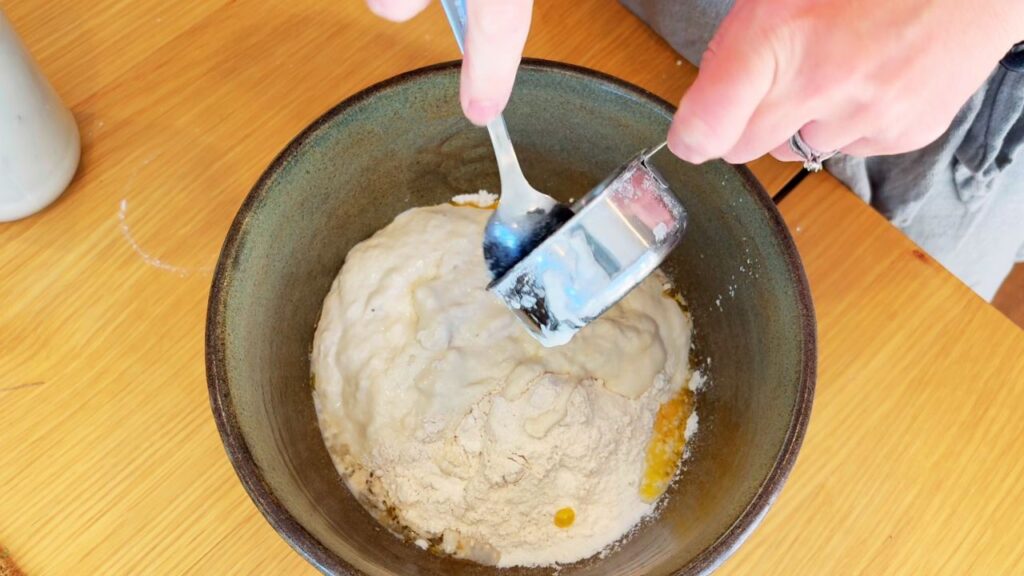 Stirring flour mixture to form sourdough bread dough made without vegetable oil.