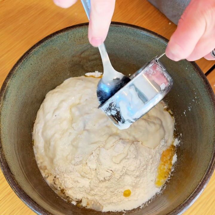Stirring flour mixture to form sourdough bread dough made without vegetable oil.