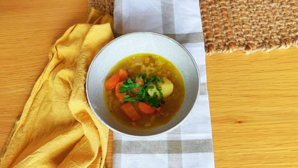 Homemade gut friendly vegetable soup with carrots, potatoes, and fresh parsley.