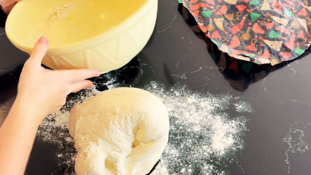 Kneading soft sourdough bread dough on a floured countertop for a healthy, seed-oil-free loaf.