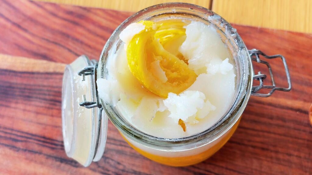 Glass jar of preserved lemons in salt and their own juices, a bright real-food condiment for gut health.