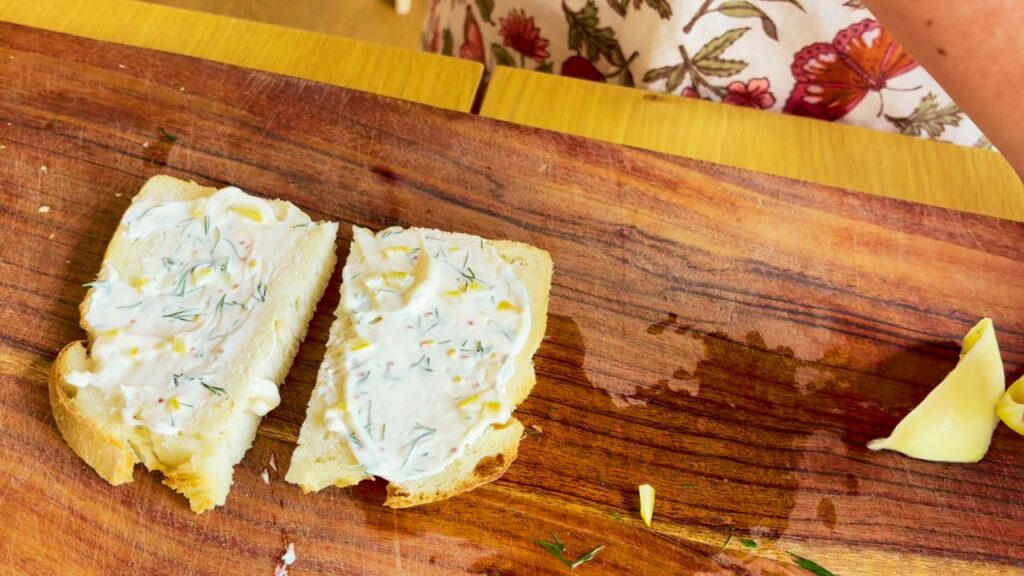Slices of sourdough bread spread with preserved lemon mayo and fresh herbs, ready for a simple gut-healthy sandwich.