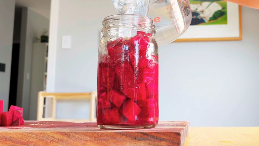 Pouring water over beetroot to begin fermenting a beetroot kvass recipe