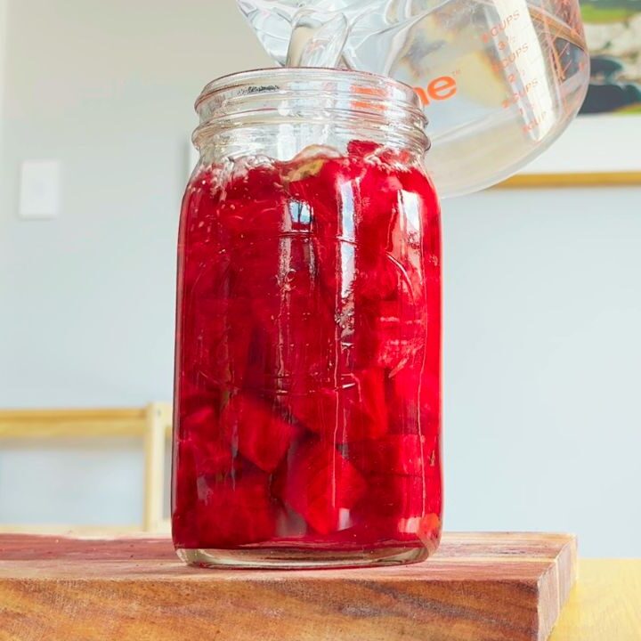 Pouring water over beetroot to begin fermenting a beetroot kvass recipe