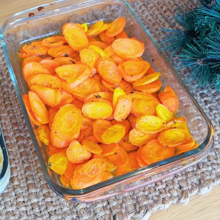 Honey–roasted carrots in a glass baking dish, one of the simple holiday side dishes prepared ahead for Christmas.