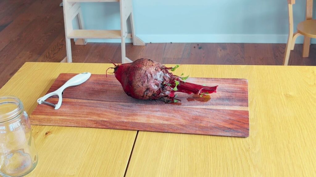 Whole beetroot ready to prepare for a beetroot kvass recipe on a wooden chopping board