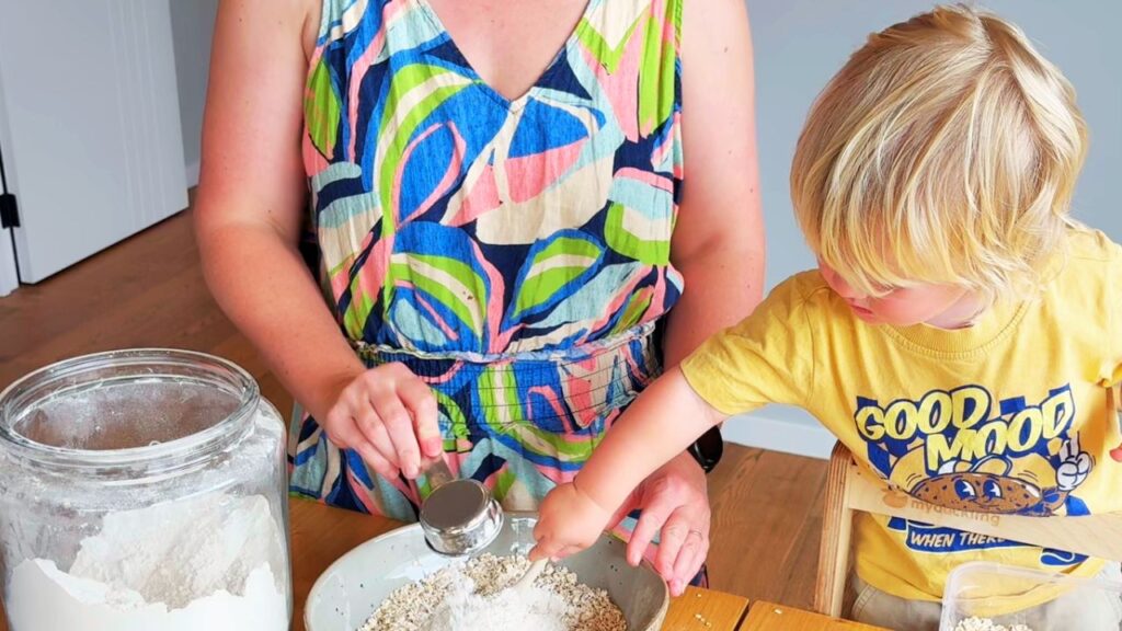Baking oat and raisin cookies with a toddler, measuring dry ingredients together