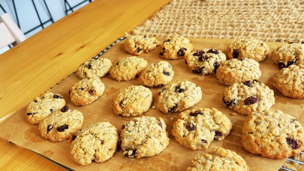 Tray of soft oat and raisin cookies baked for toddlers, cooling on parchment paper