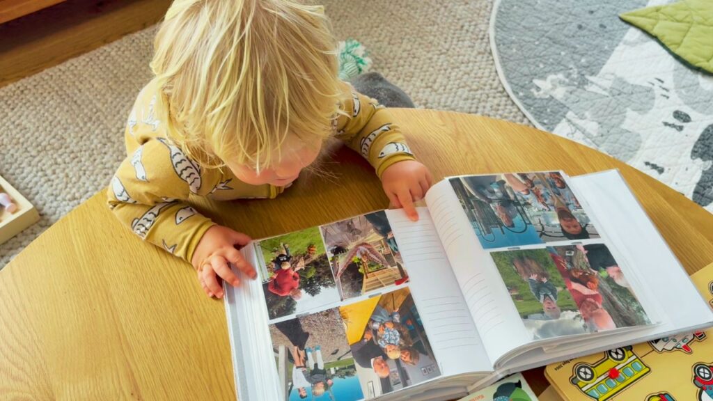 Toddler looking through a photo album of family memories during a calm morning at home