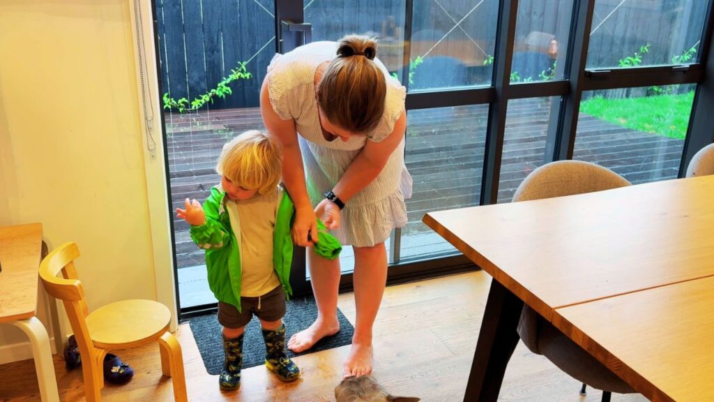 mother helping toddler get ready to go outside at a gentle pace